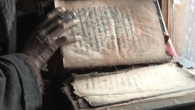 Agafia bladert door een oud gebedenboek