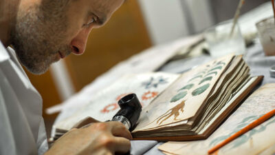 Onderzoeker aan het werk op een facsimile van het manuscript