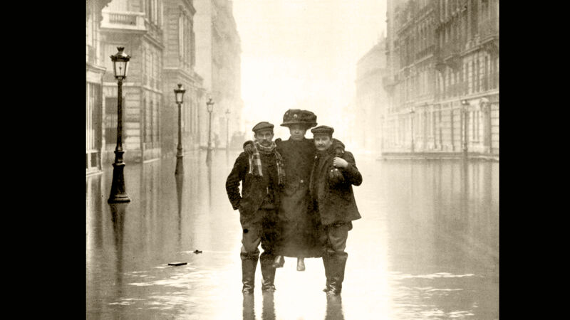 Twee Parijzenaars dragen een dame in Rue des Archives