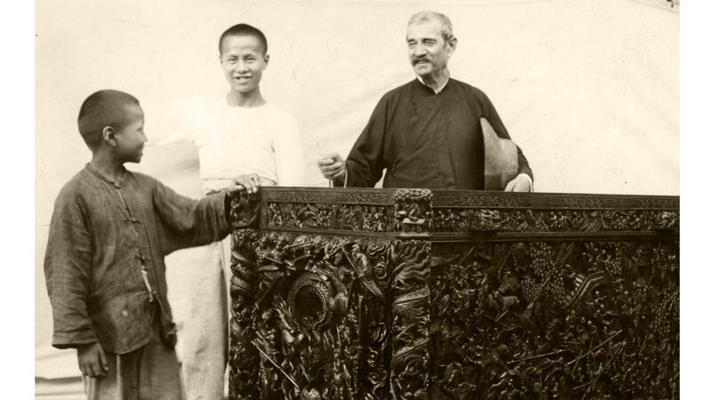 Broeder Beck en twee Chinese jongens bij een afgewerkt stuk uit het houtatelier