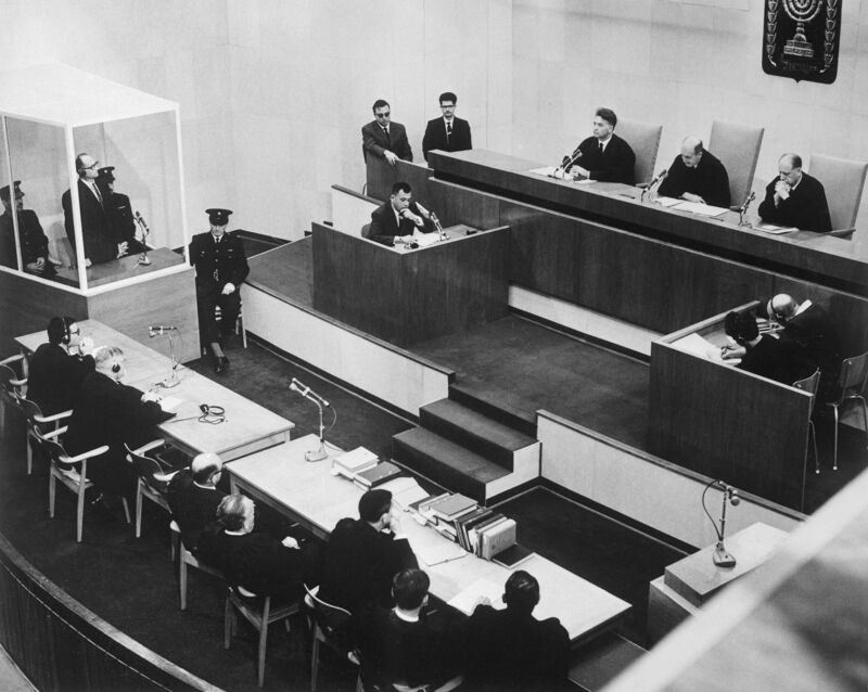 Eichmann in de glazen kooi, links, tijdens zijn proces in Jeruzalem. Hij werd veroordeeld tot de dood door ophanging voor zijn rol in de massamoord op de joden.