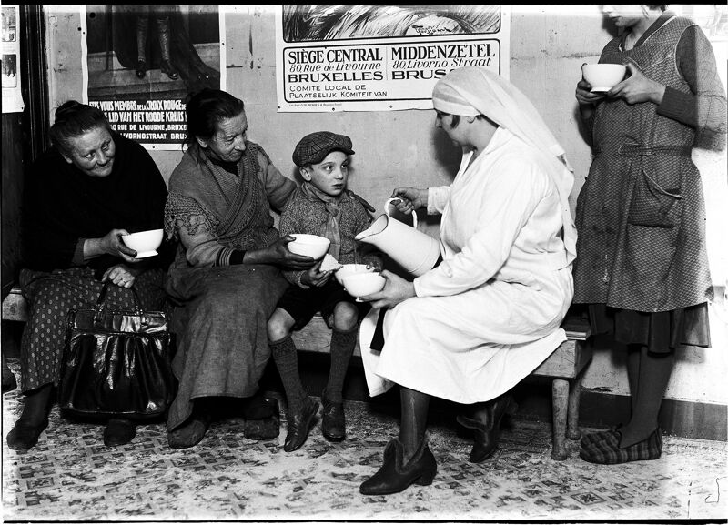 (1933) Een vrijwilligster van het Rode Kruis deelt soep en boterhammen uit aan mensen in nood.