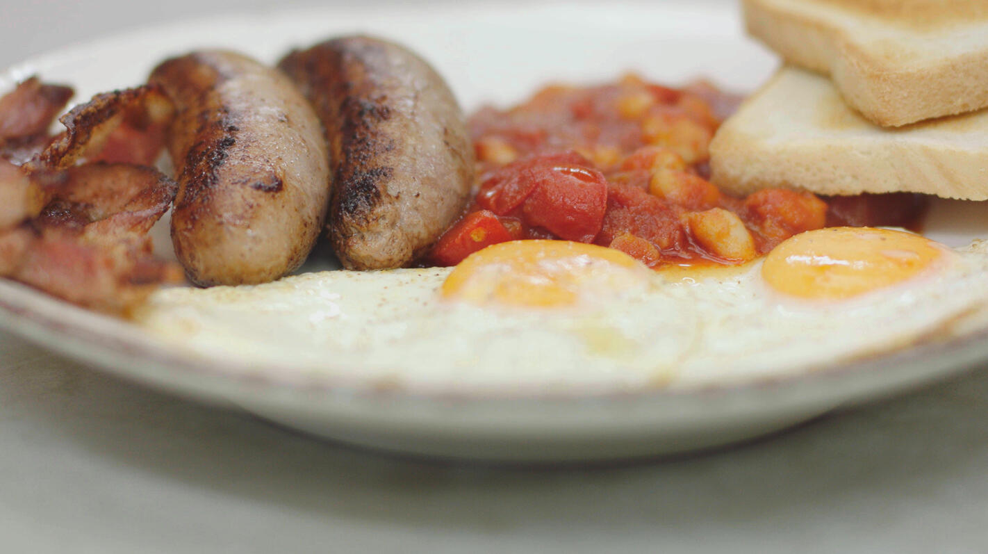 Een Engels ontbijt: Baked beans  met spek, worstjes, ei en toast