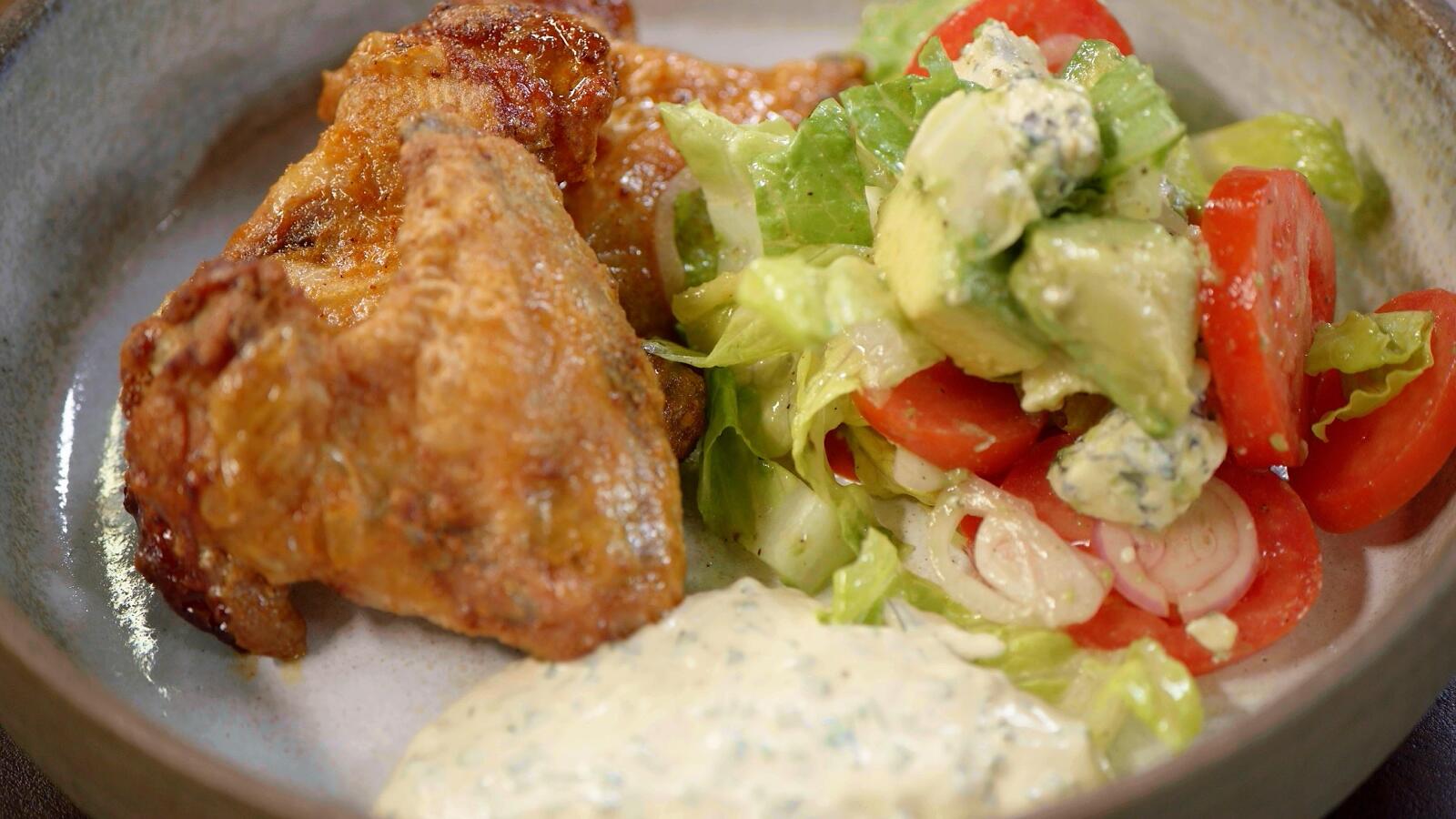 Pikante kippenvleugels, salade met blauwe kaas, avocado en ranch dressing