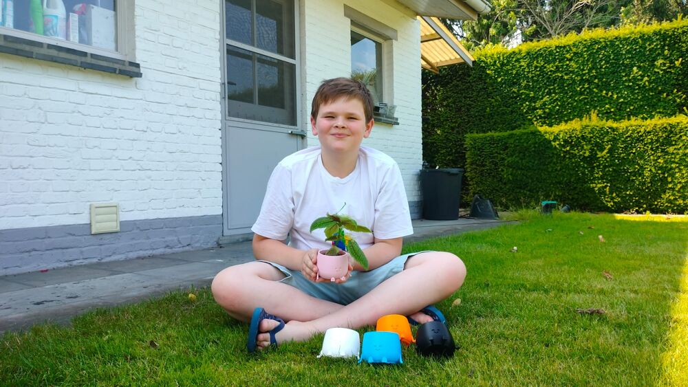 Foto Alexandre zamelt geld in met de verkoop van kleine bloempotjes. Foto: Maxime De Brouwer