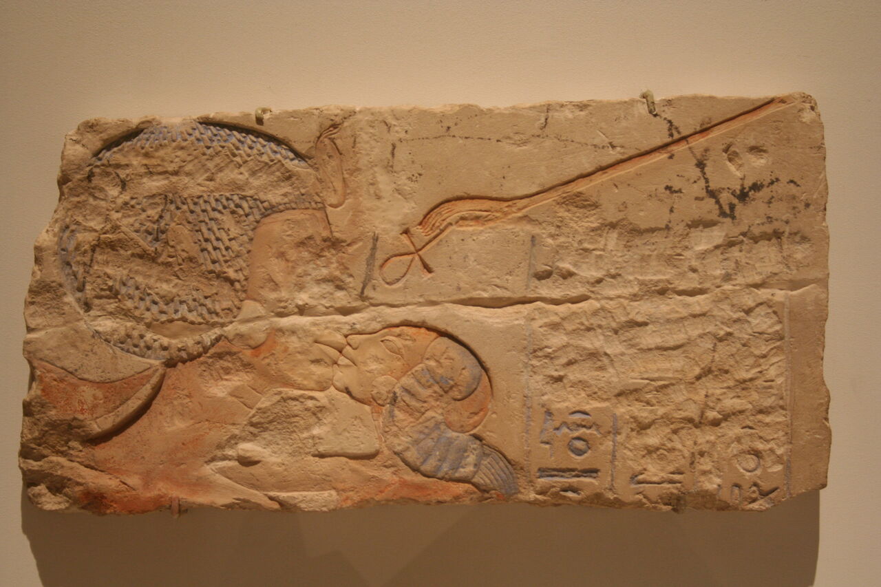 Een reliëf van Nefertiti die een van haar dochtertjes kust. Nefertiti was de vrouw van de "ketterkoning" Echnaton, en na zijn dood hebben de priesters van Amon heel wat van zijn afbeeldingen en ook van Nefertiti vernietigd. Hier is heel haar gezicht en ook een deel van de tekst weggehakt. 