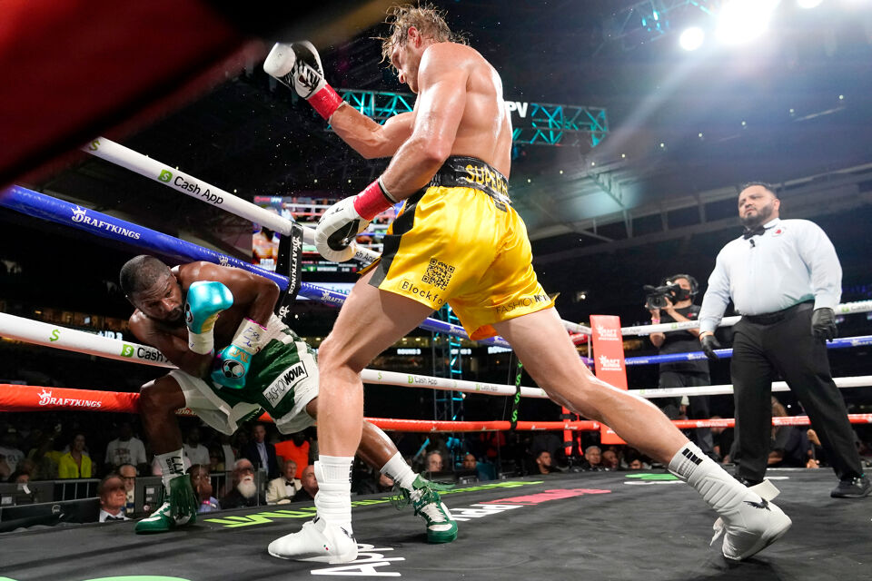 Floyd Mayweather (links) ontwijkt een klap van Logan Paul