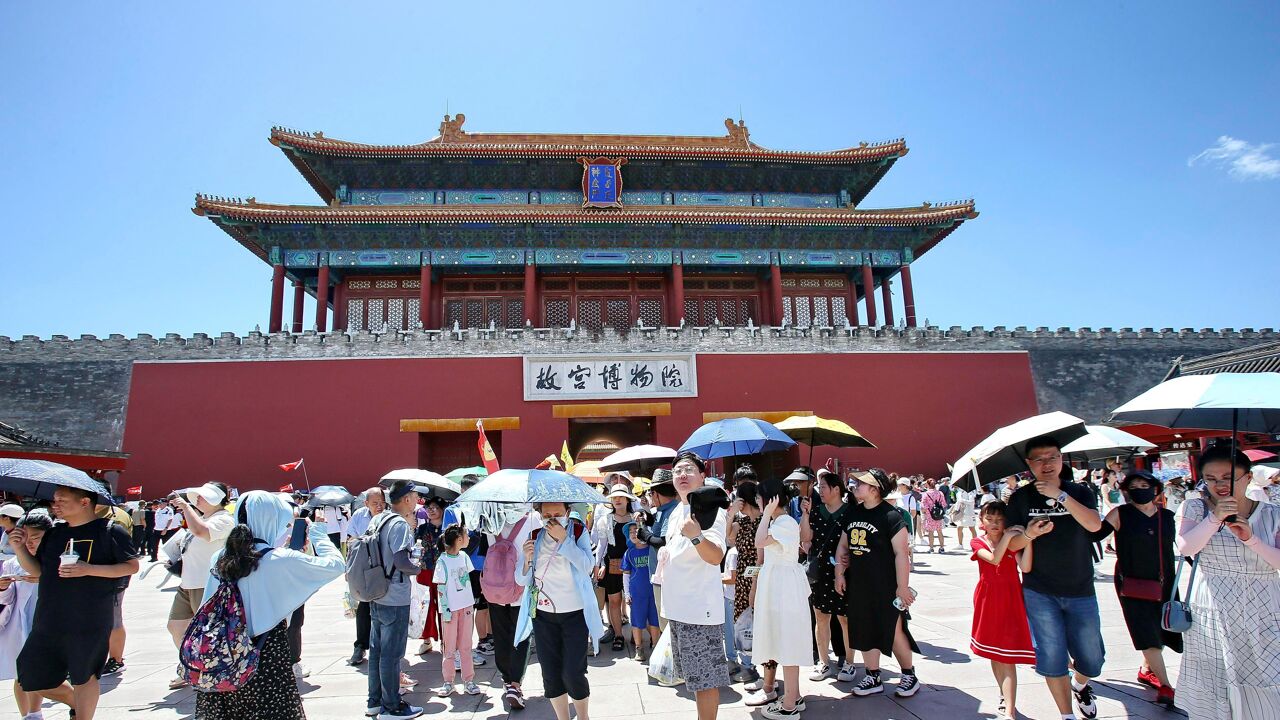 Visitors in Beijing protect themselves from the heat. Visitors in Beijing protect themselves from the heat.