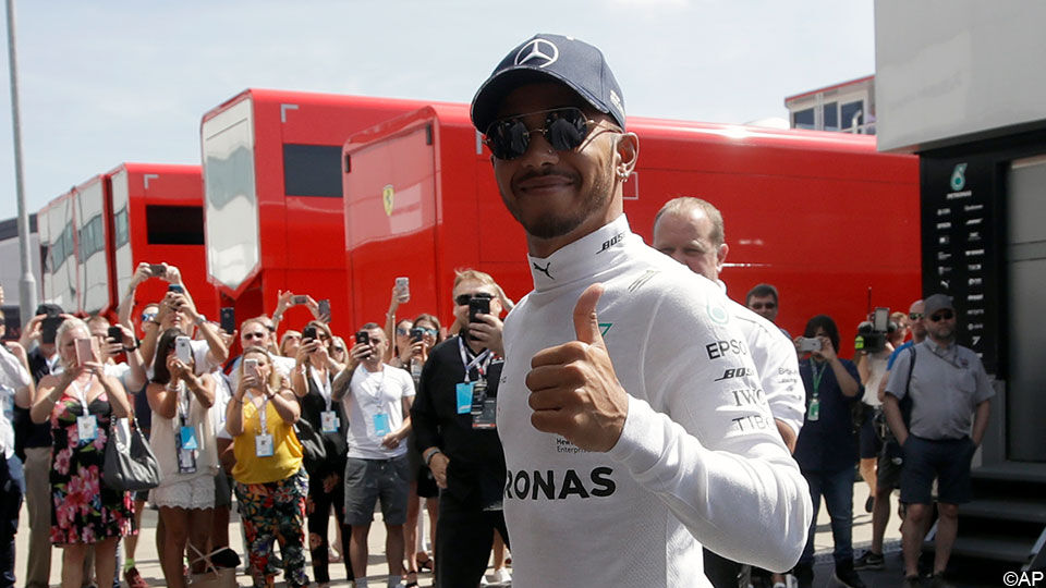 Foto van een tevreden Lewis Hamilton.