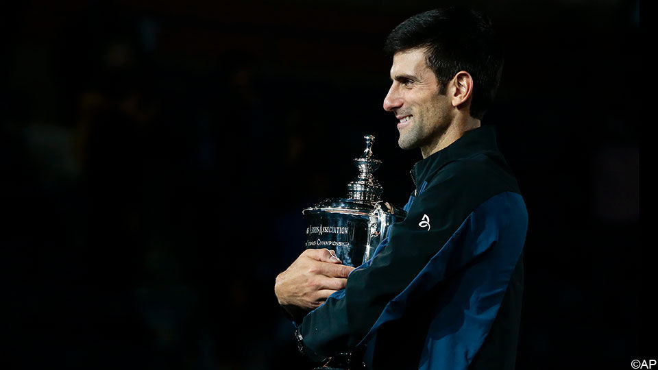 Novak Djokovic omarmt zijn 3e US Open-trofee.