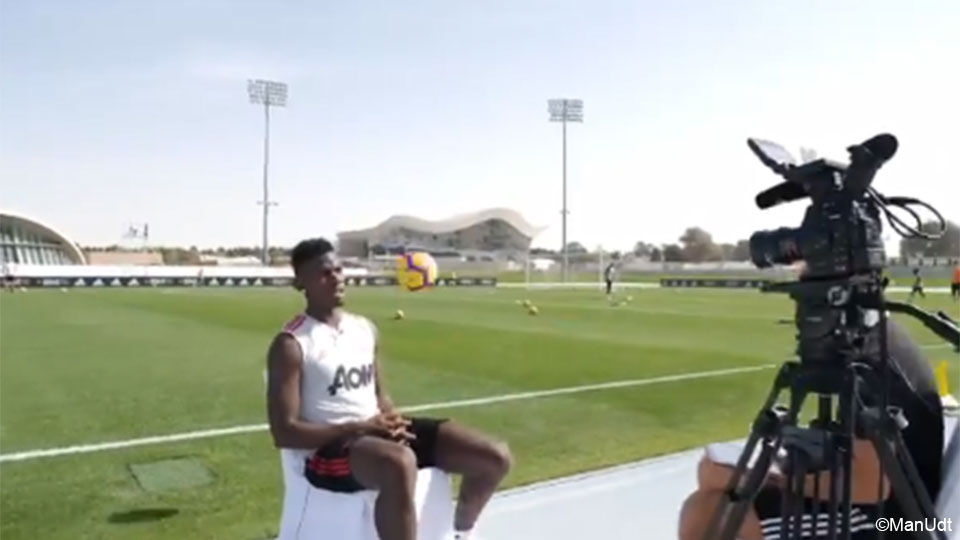 Paul Pogba zit voor het voetbalveld een interview te geven.