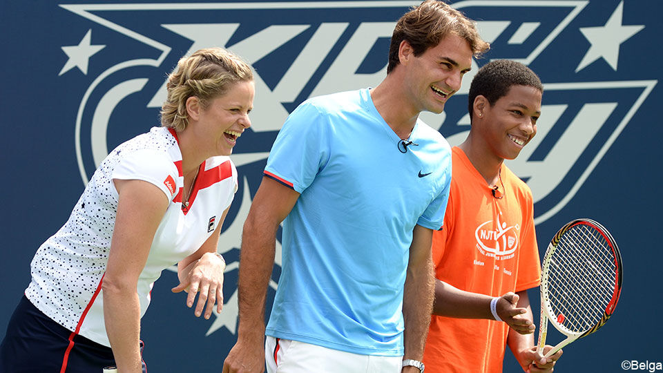 Kim Clijsters en Roger Federer staan naast elkaar op het tennisveld en lachen.