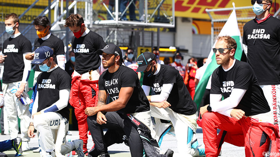 Sebastian Vettel (rechts) knielend voor de race.