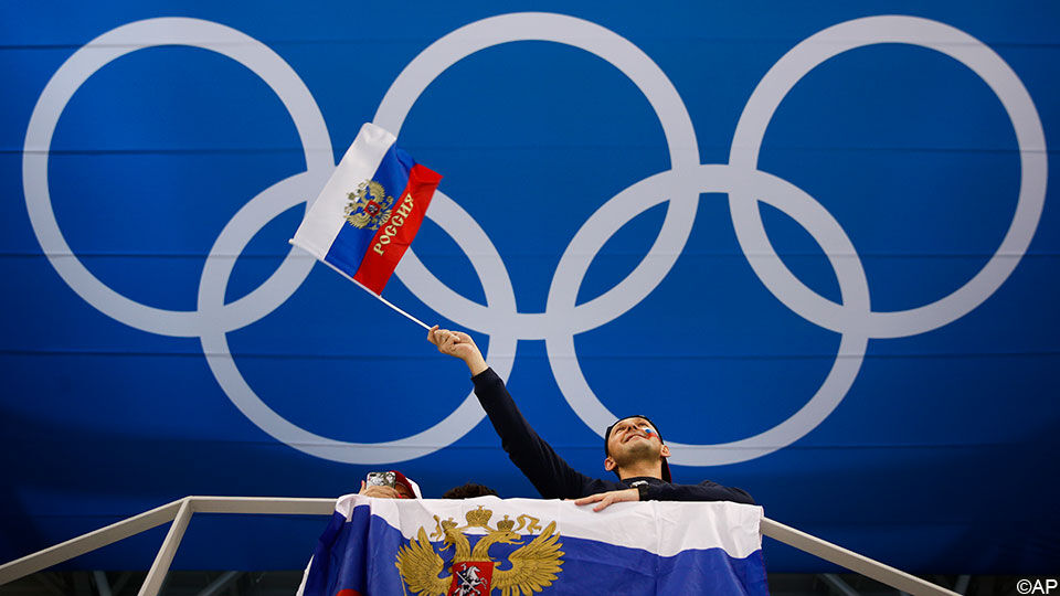 Russische vlag die wappert voor de Olympische ringen.