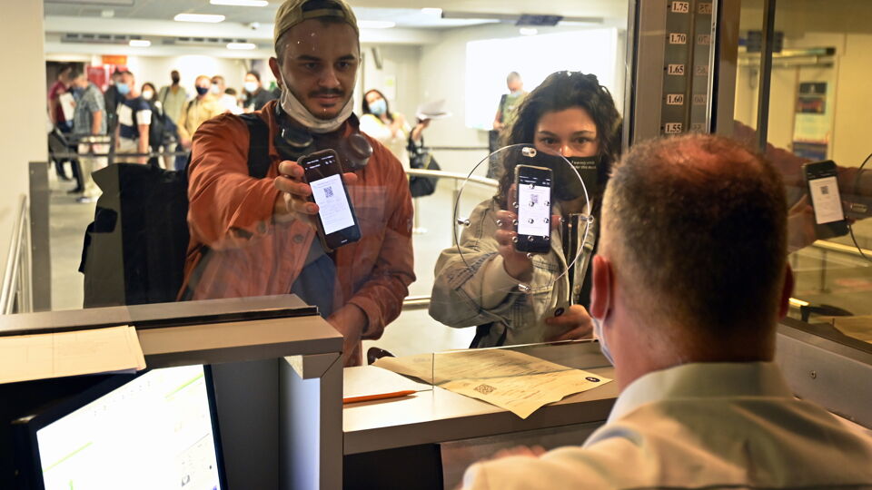 Archiefbeeld louter ter illustratie: reizigers tonen een document aan een agent van de luchtvaartpolitie.