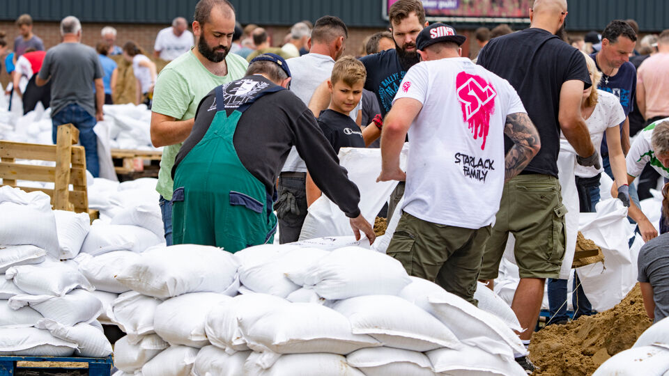 Vrijwilligers helpen met het vullen van zandzakjes in Venlo.