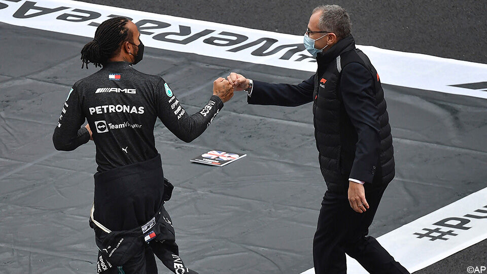 Lewis Hamilton krijgt een vuistje van F1-CEO Stefano Domenicali.