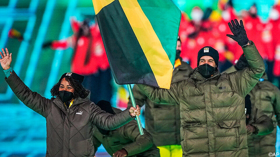Benjamin Alexander draagt samen met bobsleester Jazmine Fenlator-Victorian de Jamaicaanse vlag tijdens de openingsceremonie.