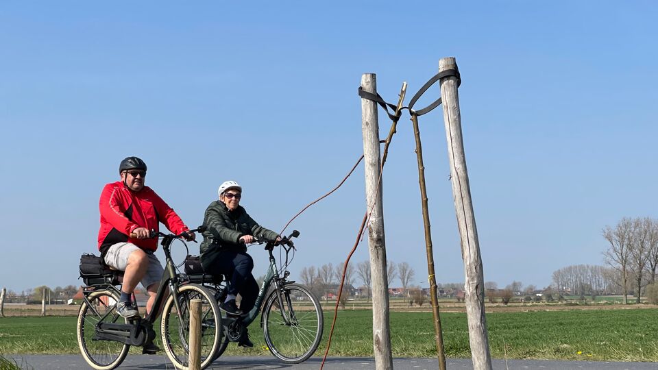 Een van de afgeknakte bomen met enkele passerende fietsers