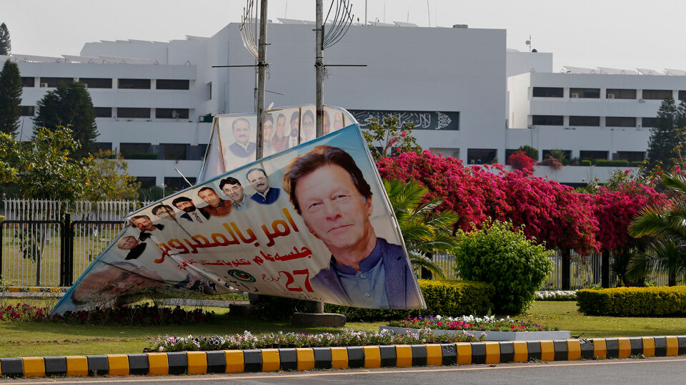 Een omgewaaid spandoek van premier Imran Khan buiten het parlementsgebouw in Islamabad.