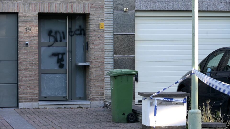 Voorgevel van een huis. Op de deur is met verf het woord snitch gespoten