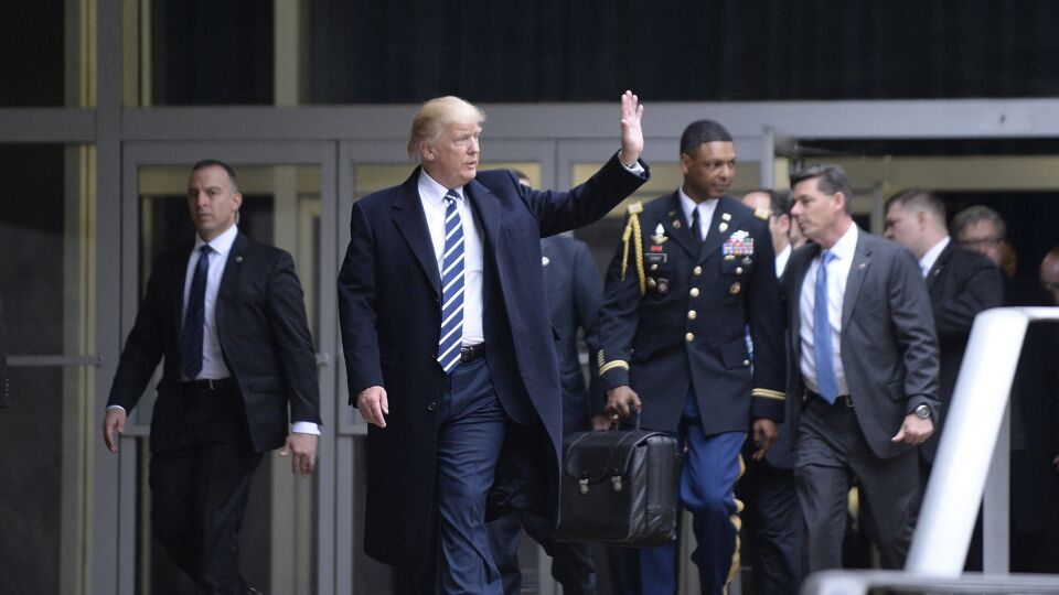 Archiefbeeld: Donald Trump in 2017, met in de achtergrond een militair met de nucleaire codes. 