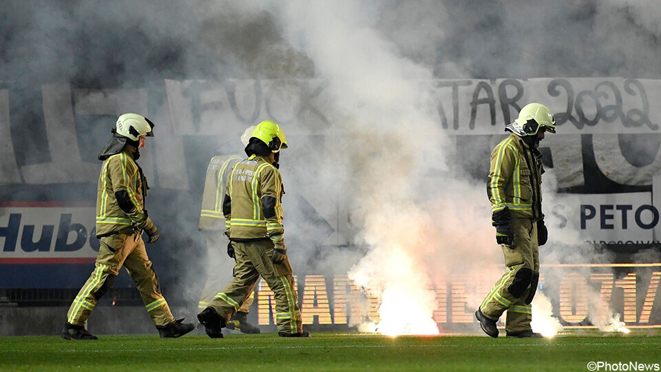 Brandweermannen doven op het veld de vuurpijlen van de Charleroi-fans uit.