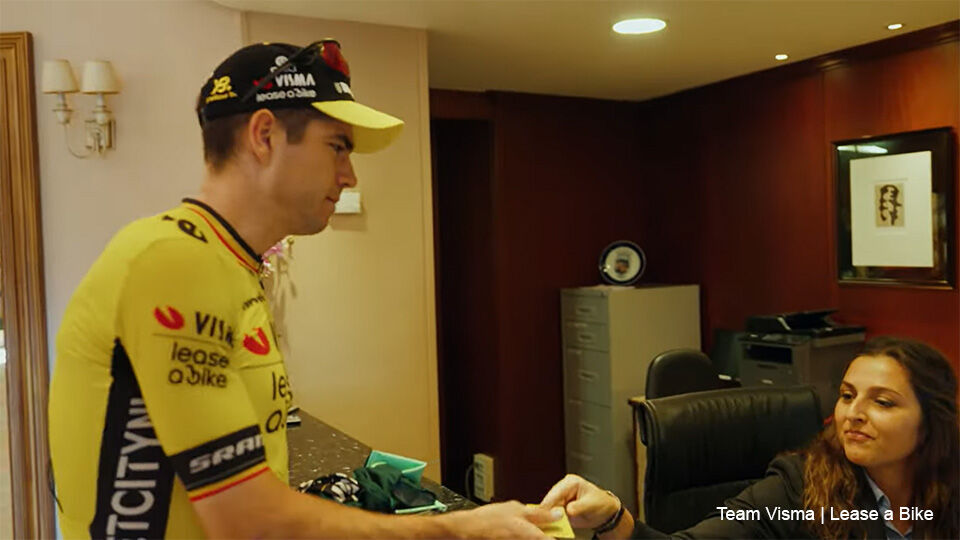 Wout van Aert krijgt hulp van de receptioniste voor zijn kamernummer.